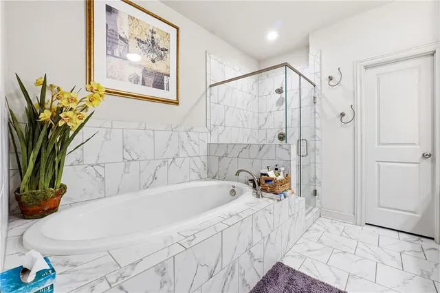 a white bath tub sitting next to a blue plant