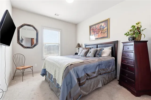 a bedroom with a bed and a chair with the potted plants