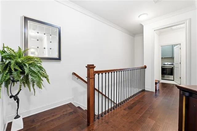 a view of a hallway with wooden floor and a potted plant