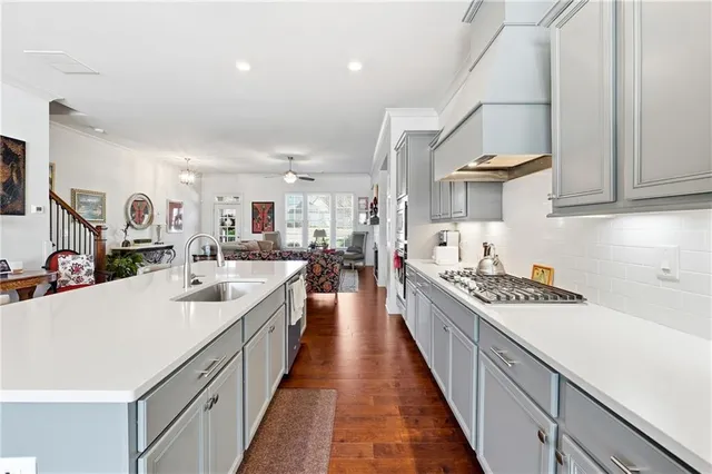 a kitchen with kitchen island stainless steel appliances a sink stove and cabinets
