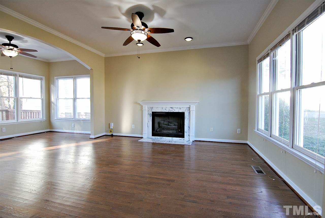 2216 Dahlgreen Road Raleigh, NC 27615 - Photo 3 of 22 an empty room with wooden floor fireplace and windows
