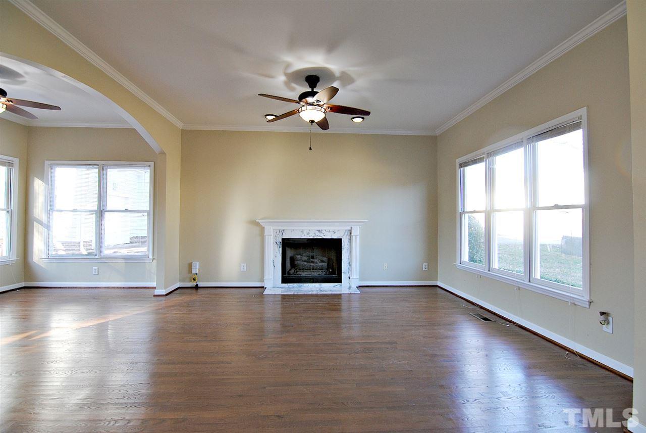 2216 Dahlgreen Road Raleigh, NC 27615 - Photo 5 of 22 an empty room with wooden floor a chandelier fan and windows