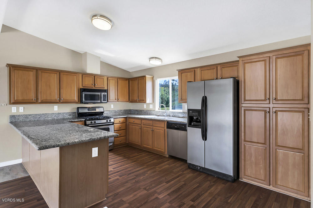 15535 LaPeyre Road Moorpark, CA 93021 - Photo 13 of 34 a kitchen with granite countertop stainless steel appliances a refrigerator sink microwave and cabinets