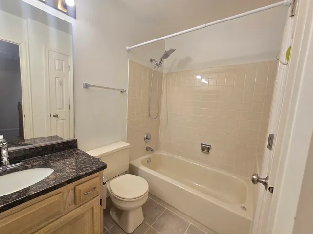 a bathroom with a granite countertop sink a toilet and shower