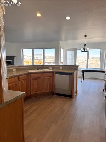 a large kitchen with a window and wooden floor