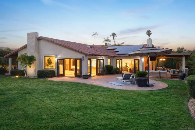 a view of a house with a backyard and patio