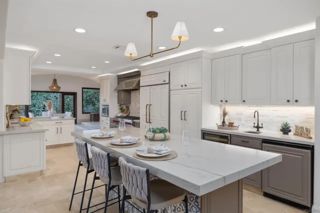 a kitchen with stainless steel appliances kitchen island granite countertop a dining table and chairs