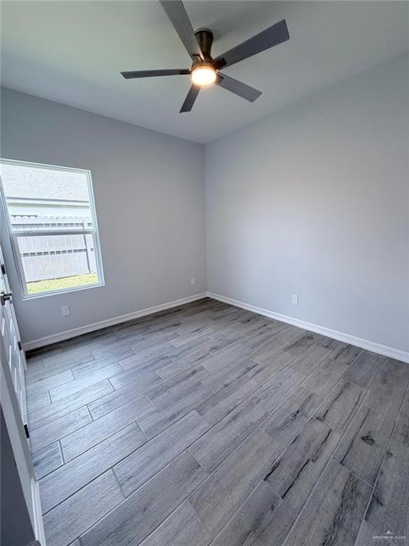 1724 Clinton Street Harlingen, TX 78550 - Photo 7 of 23 wooden floor in an empty room with a window