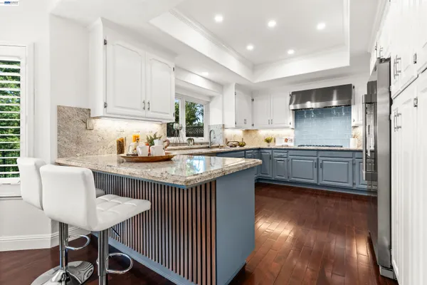 a kitchen with granite countertop a sink cabinets and wooden floor