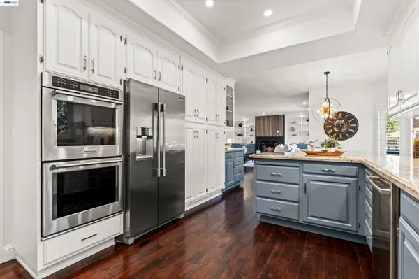 a kitchen with cabinets stainless steel appliances and wooden floor