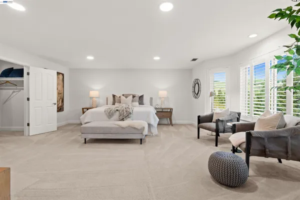 a spacious bedroom with bed and a couch