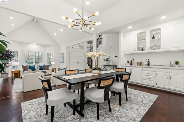 a dining room with wooden floor a chandelier a wooden table and chairs