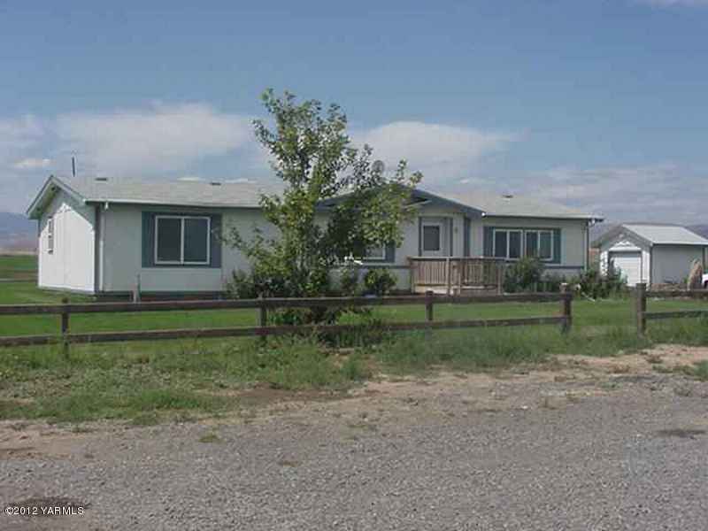 630 Hinman Road Harrah, WA 98933 - Photo 1 of 4 a view of house in front of a big yard with large trees