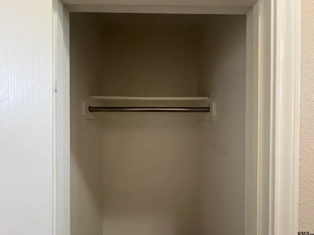 an empty room with wooden floor chandelier and windows