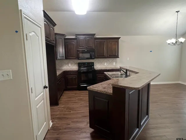 a kitchen with stainless steel appliances granite countertop a refrigerator and a stove top oven