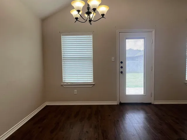 a view of wooden floor fire place and windows in a room