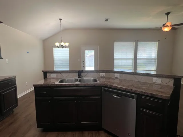 a kitchen with granite countertop wooden cabinets and stainless steel appliances