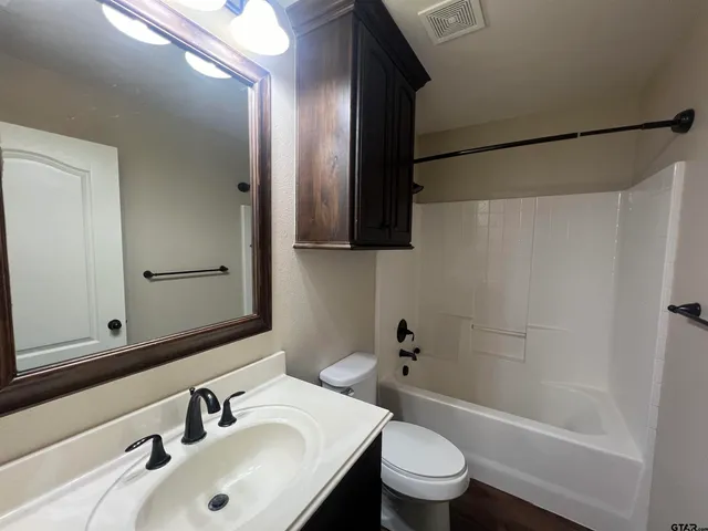 a bathroom with a sink a toilet and a mirror
