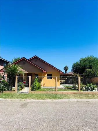 a backyard of a house with table and chairs under an umbrella