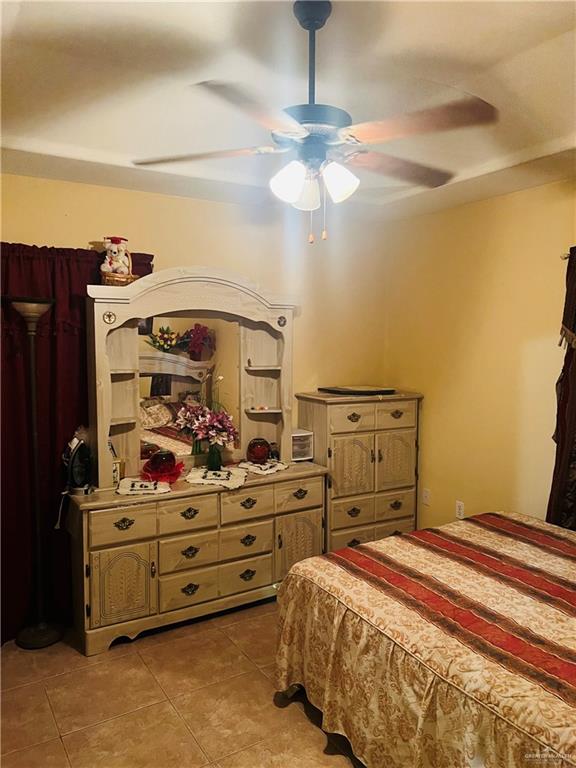 2349 Elaine Street Roma, TX 78584 - Photo 12 of 16 a bedroom with a bed and a chandelier