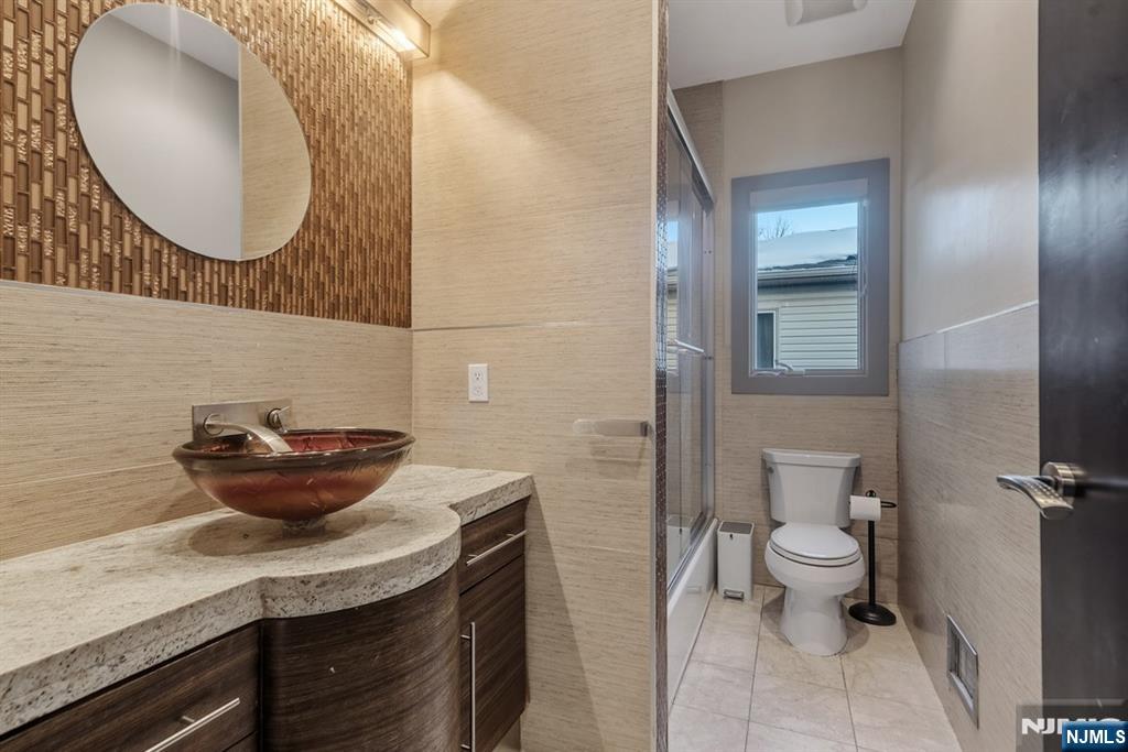 760 Undercliff Avenue Edgewater, NJ 07020 - Photo 22 of 48 a bathroom with a granite countertop sink and a mirror