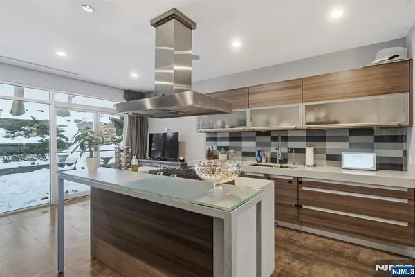 a metallic refrigerator freezer and a stove sitting inside of a kitchen