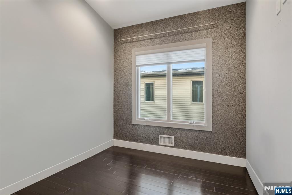 760 Undercliff Avenue Edgewater, NJ 07020 - Photo 48 of 48 a view of an empty room with wooden floor and a window