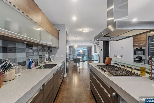 a kitchen with lots of counter top space a stove and white cabinets
