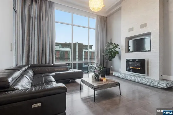a living room with furniture large window and a fireplace