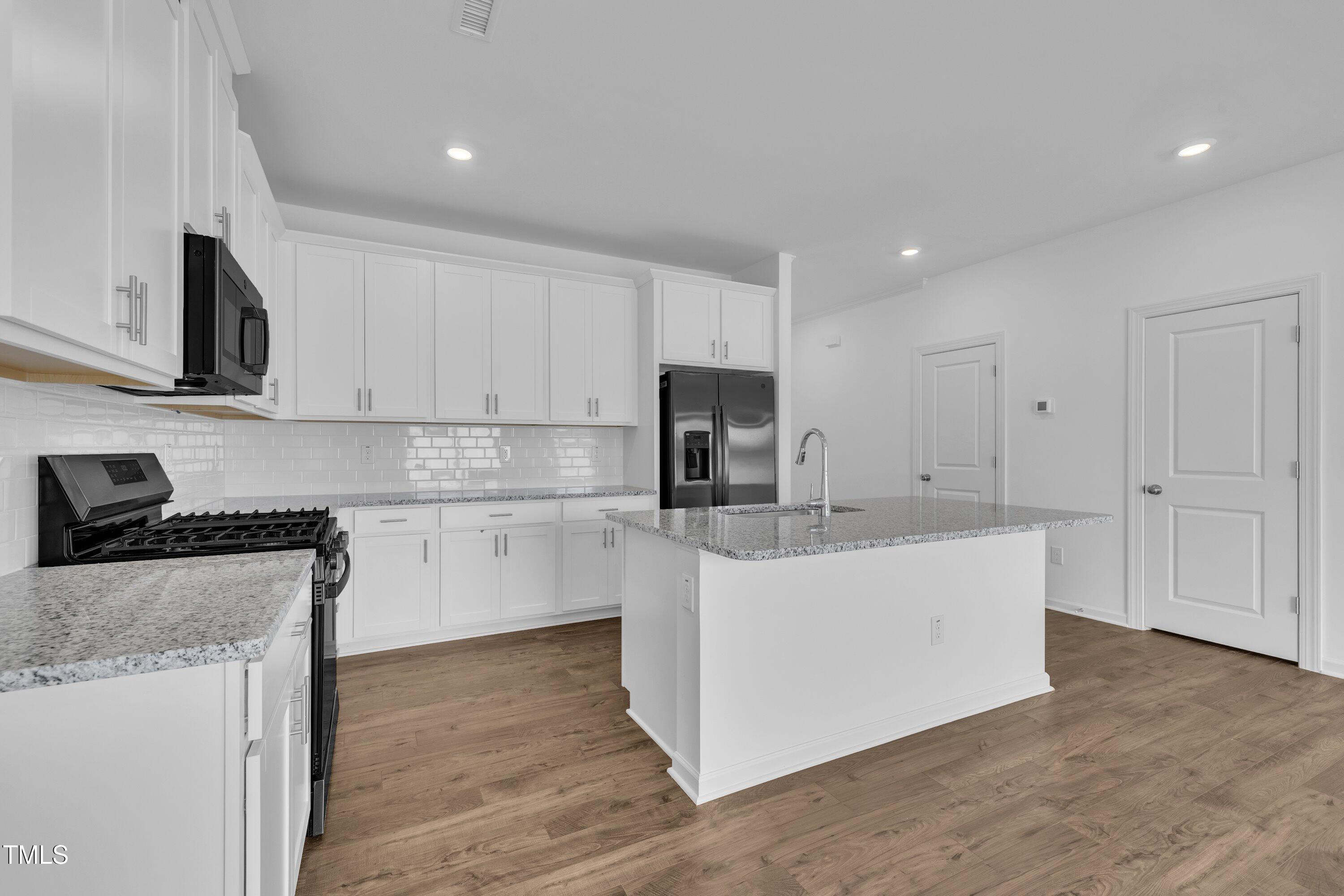 281 Hank Way Angier, NC 27501 - Photo 12 of 39 a kitchen with stainless steel appliances a sink a stove a refrigerator cabinets and a counter top space