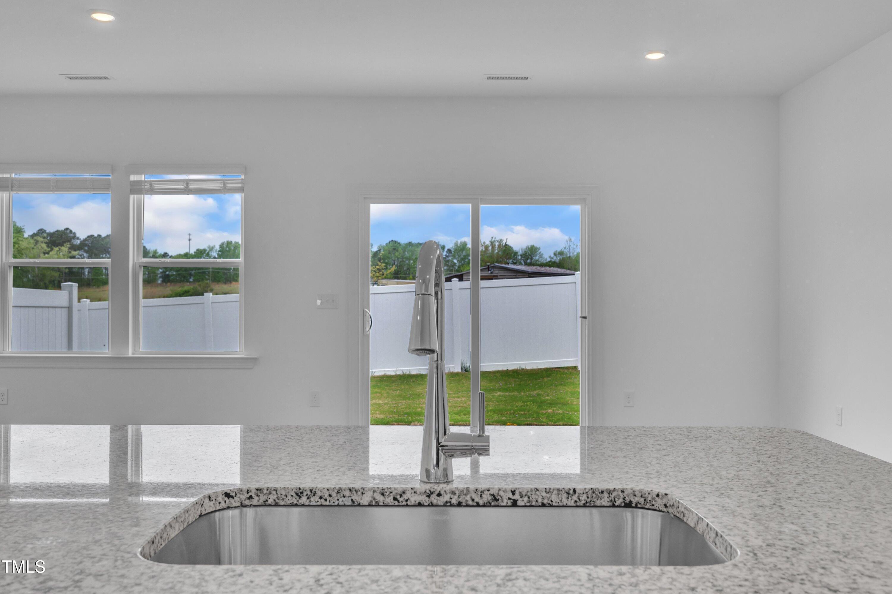 281 Hank Way Angier, NC 27501 - Photo 16 of 39 a view of kitchen island a sink wooden floor and a window