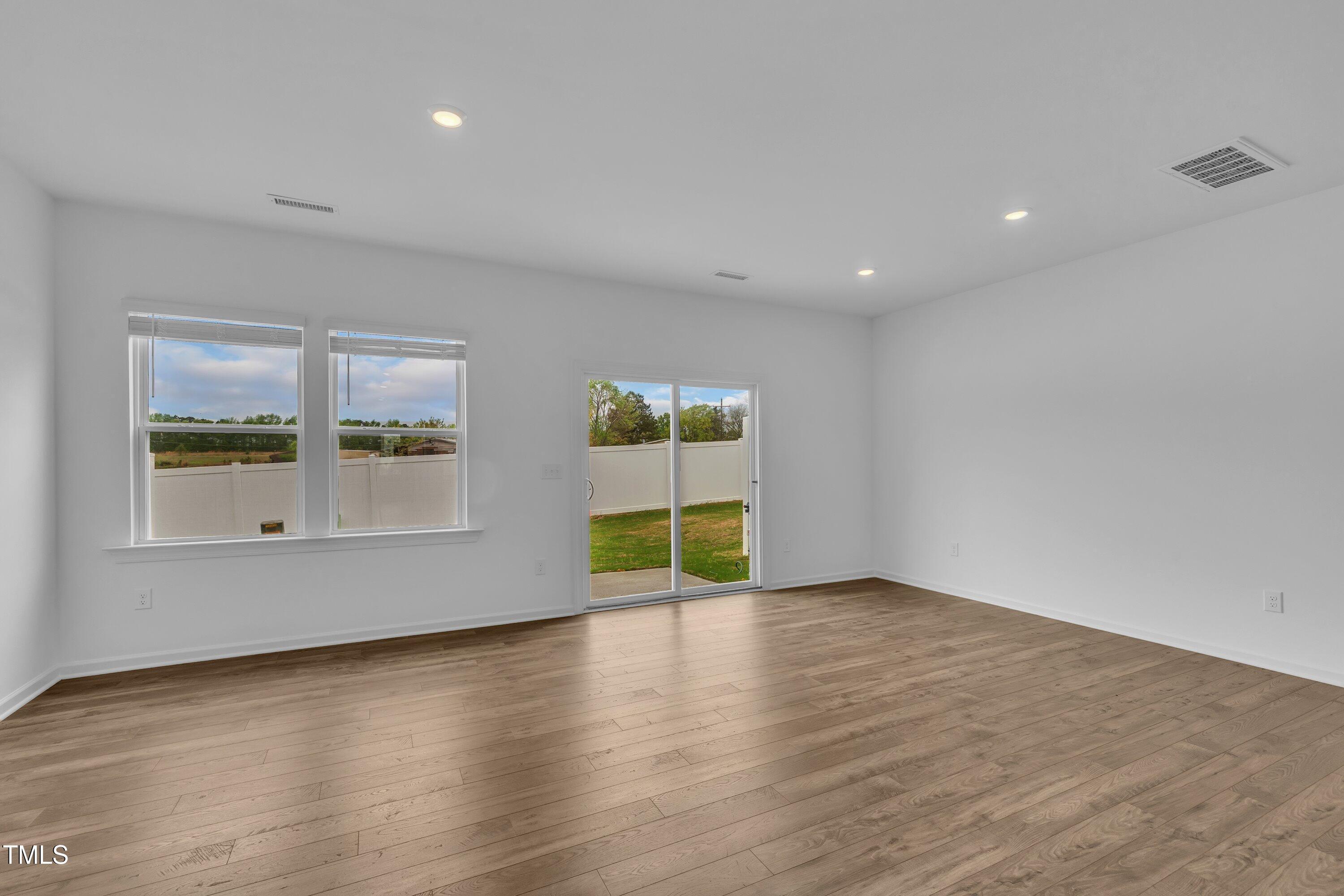 281 Hank Way Angier, NC 27501 - Photo 17 of 39 an empty room with wooden floor and windows