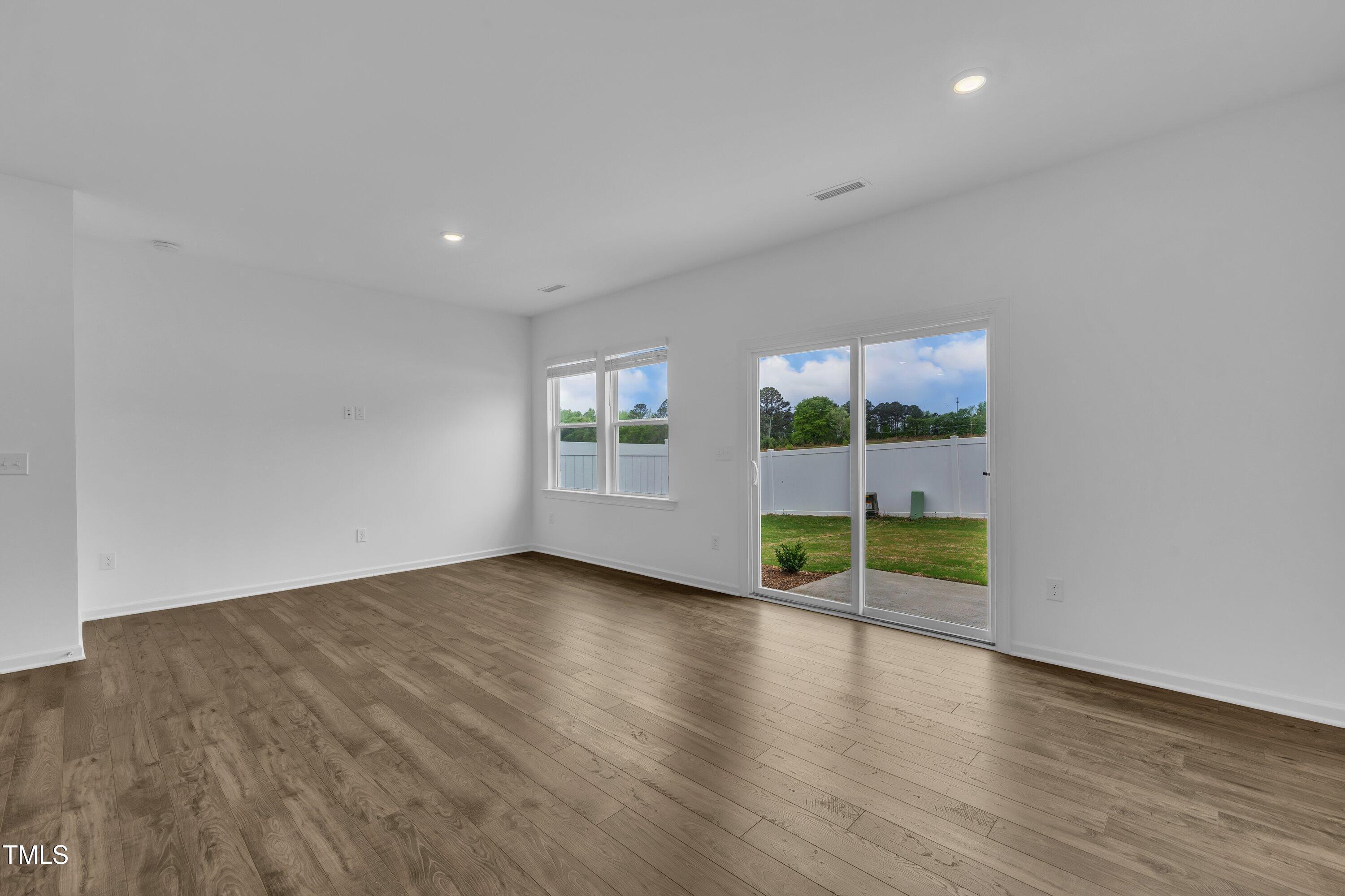 281 Hank Way Angier, NC 27501 - Photo 19 of 39 an empty room with wooden floor and windows