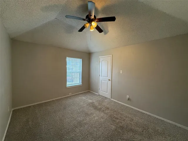 an empty room with a window and a ceiling fan