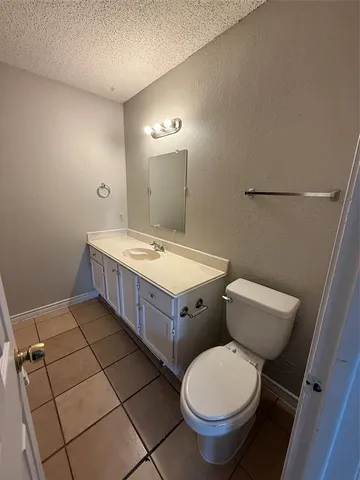 a bathroom with a granite countertop toilet sink and mirror