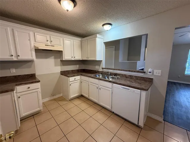 a kitchen with granite countertop white cabinets and white appliances