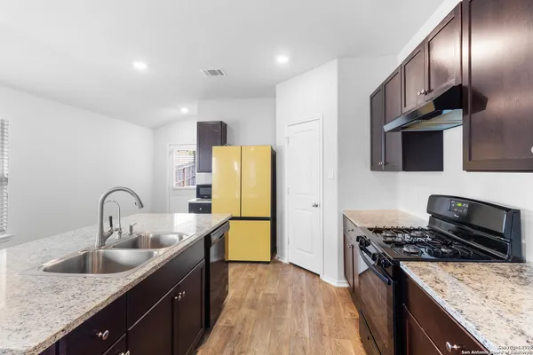 a kitchen with stainless steel appliances granite countertop a sink stove and refrigerator