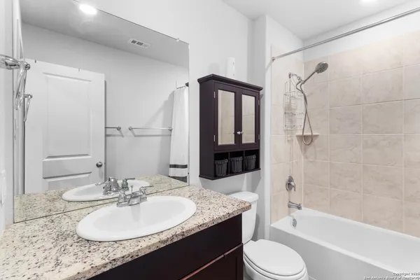 a bathroom with a granite countertop sink toilet and shower