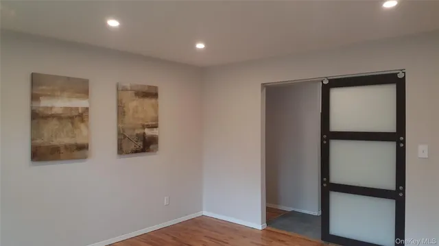 a view of empty room with wooden floor