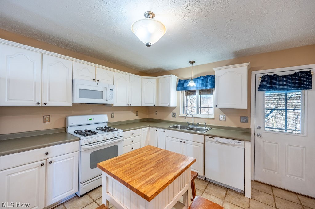 3601 River Road Vienna, WV 26105 - Photo 9 of 40 Kitchen featuring white appliances, light countertops, white cabinets, hanging light fixtures, and a textured ceiling