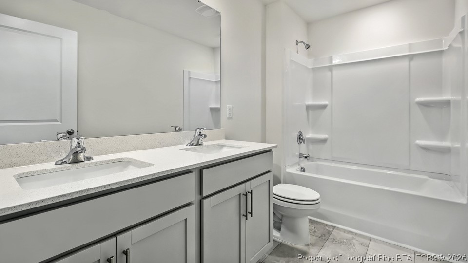 81 Discovery Way Spring Lake, NC 28390 - Photo 25 of 32 a bathroom with a sink a toilet and a large mirror