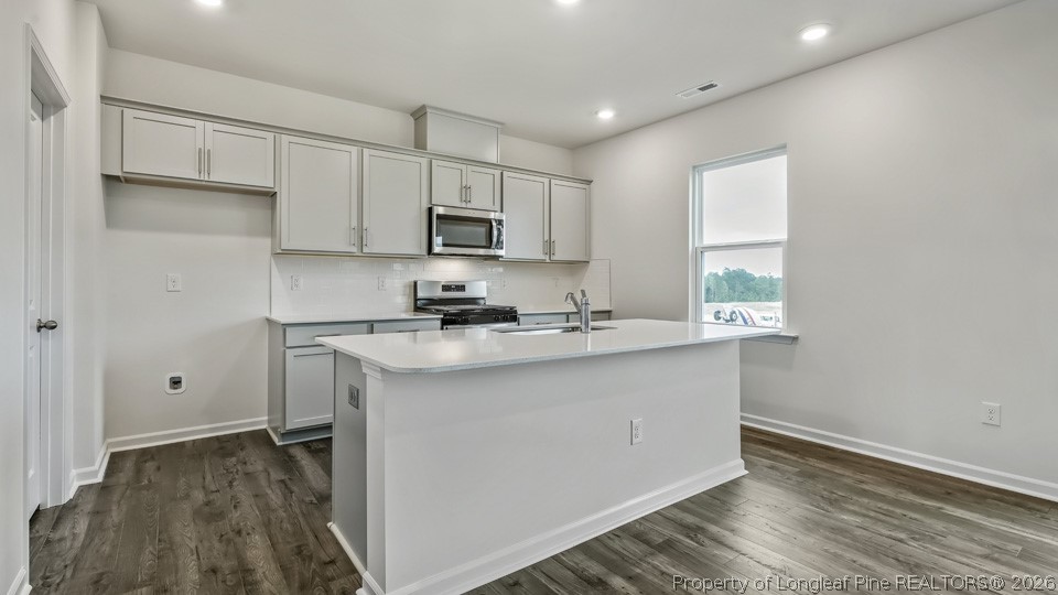 81 Discovery Way Spring Lake, NC 28390 - Photo 5 of 32 a kitchen with stainless steel appliances granite countertop a sink a stove and a refrigerator