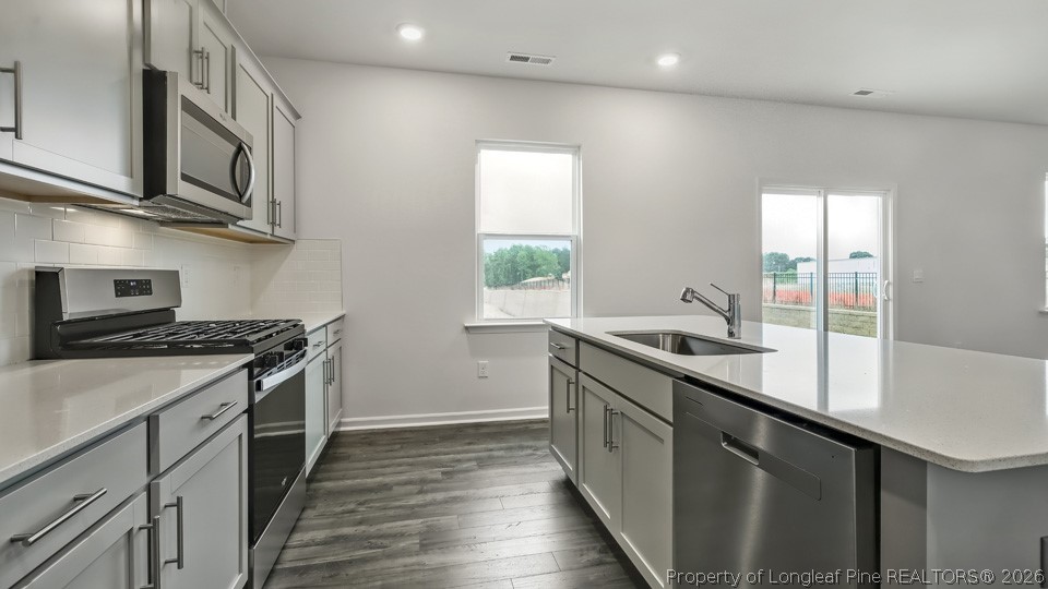 81 Discovery Way Spring Lake, NC 28390 - Photo 8 of 32 a kitchen with stainless steel appliances granite countertop a stove a sink and a microwave