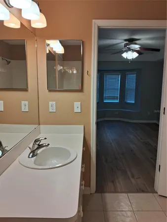 a view of a hallway with wooden floor and a bathroom