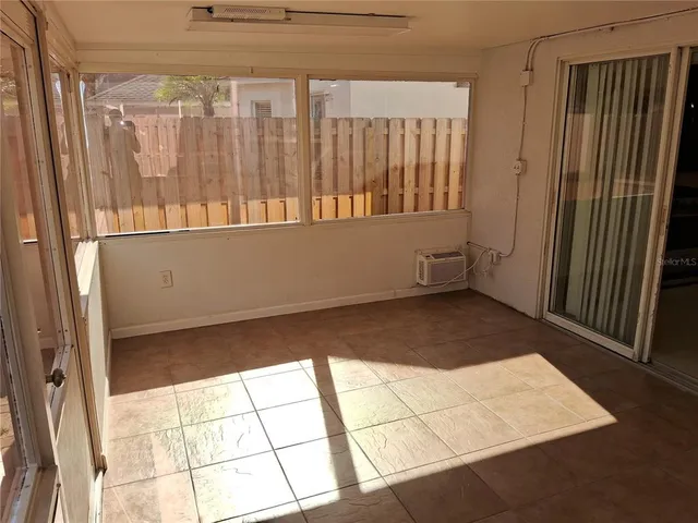 an empty room with wooden floor and a ceiling fan