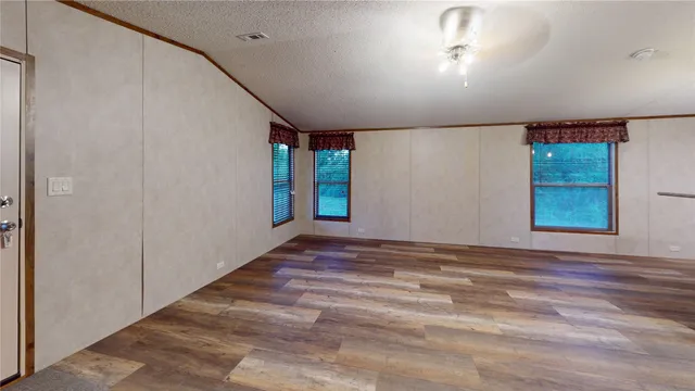 a view of an empty room with window and stairs