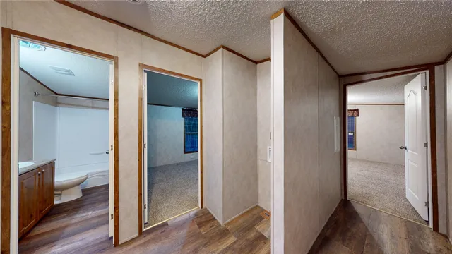 a view of hallway with bathroom and wooden floor
