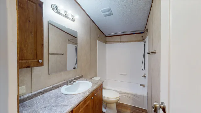 a bathroom with a granite countertop sink toilet mirror and bathtub