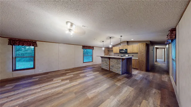 a kitchen with stainless steel appliances kitchen island granite countertop a refrigerator and a stove