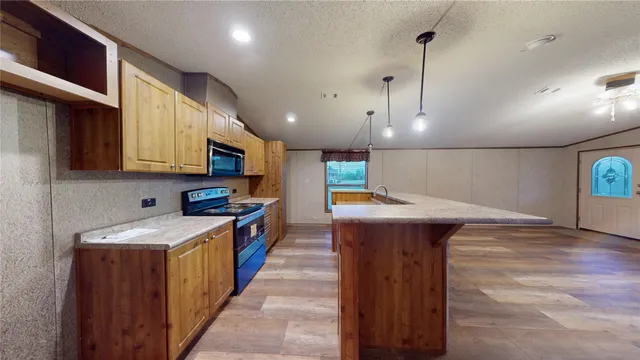 a kitchen with stainless steel appliances granite countertop wooden cabinets a sink and a stove